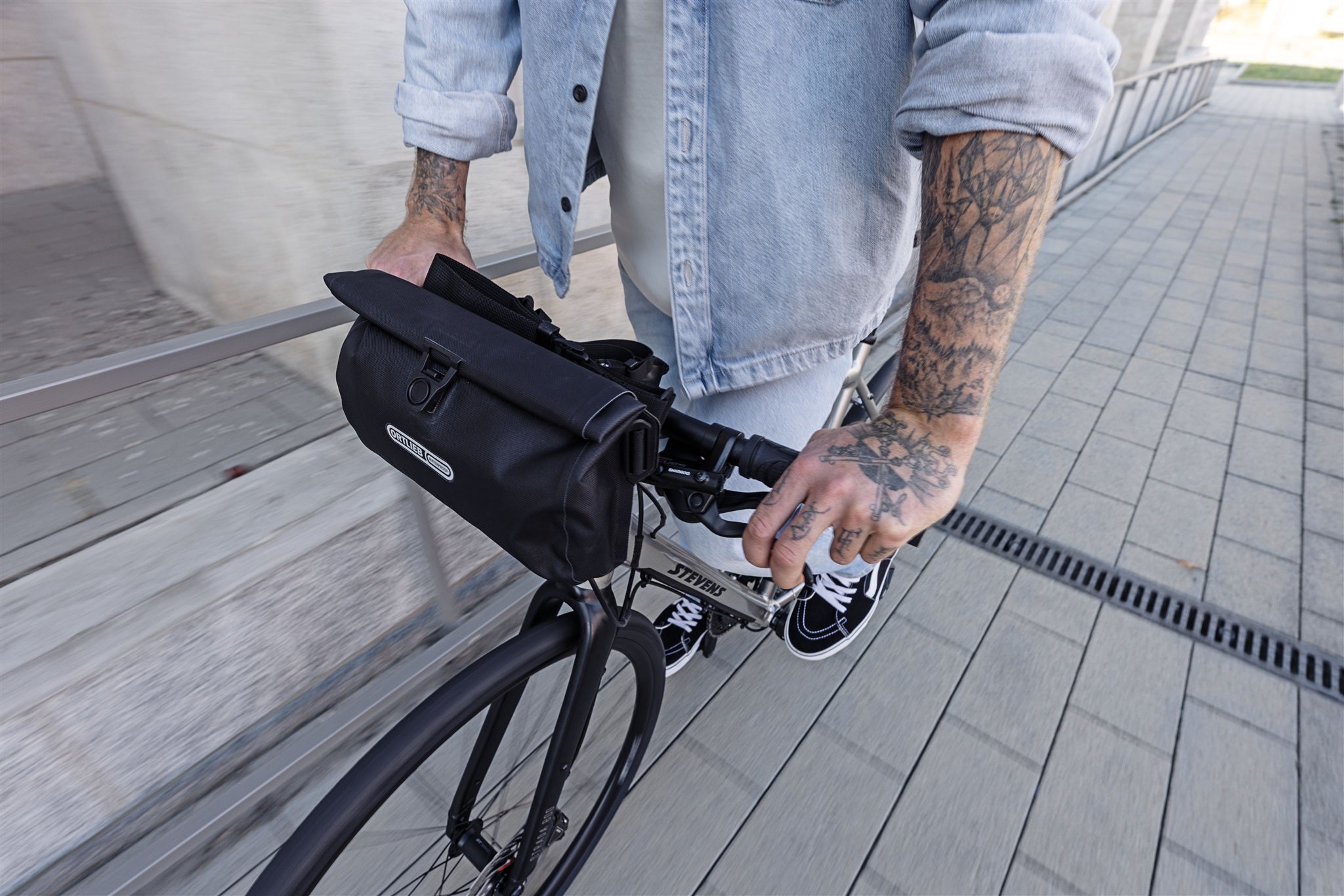 Borsa da manubrio nera ORTLIEB Velo-Sling Flex con chiusura a rotolo e sistema Bar-Lock su bici urbana.